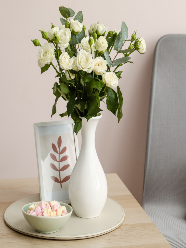 Klein wit boeket met bloemenabonnement op een bijzettafel.
